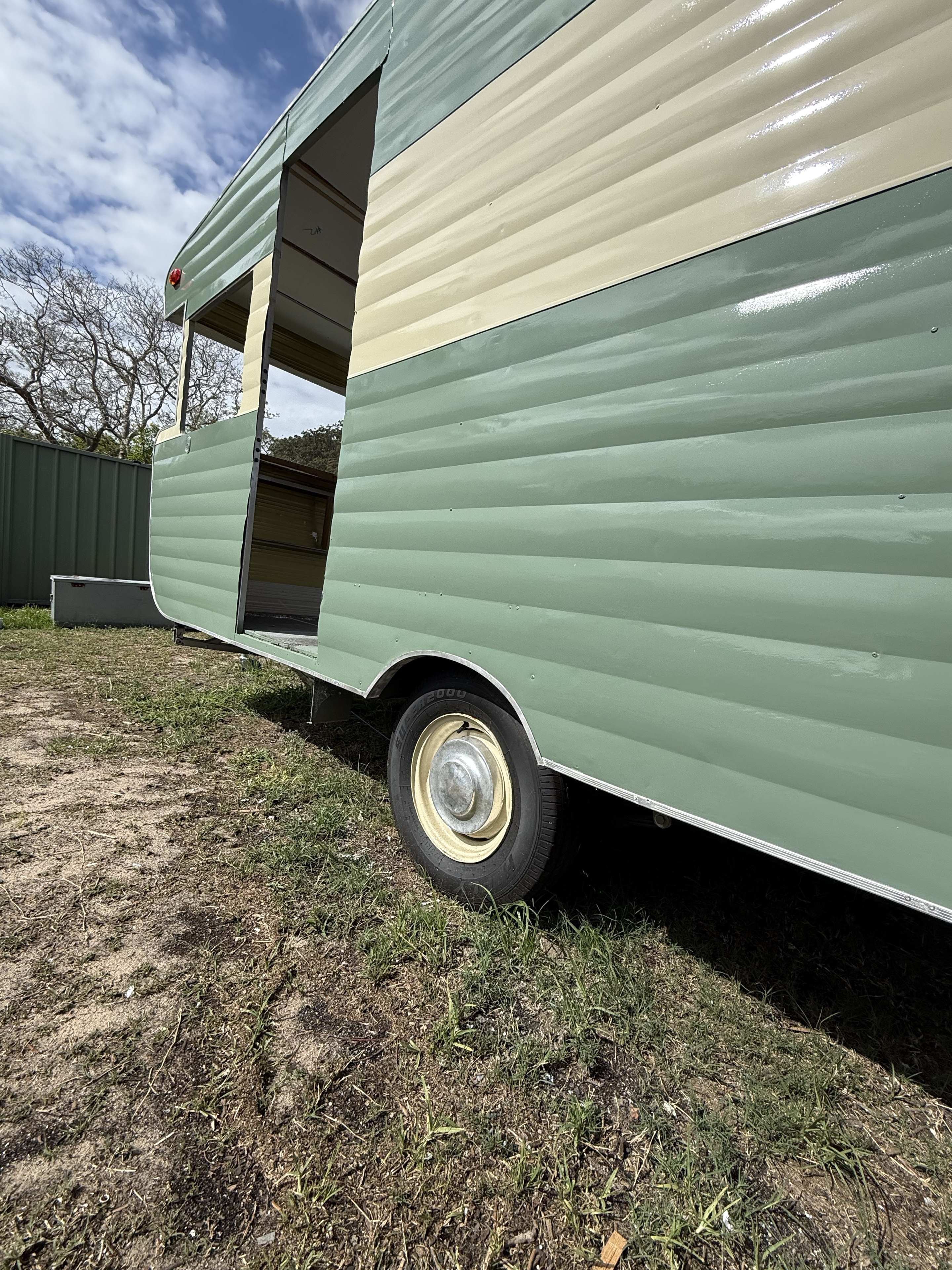 Close view of the sage-green and cream cladding and wheel during restoration.